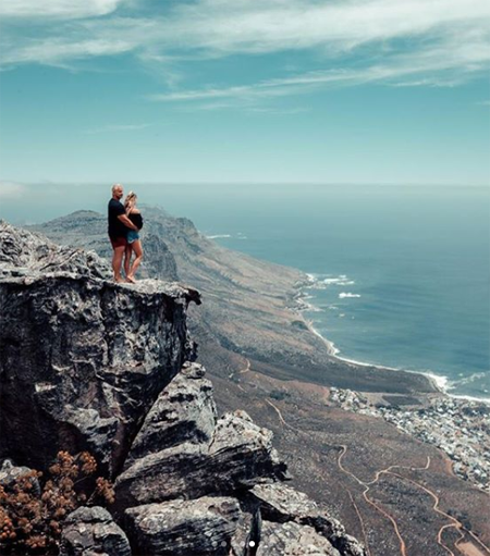 Vitaly and Kinsey are on top of the rock.